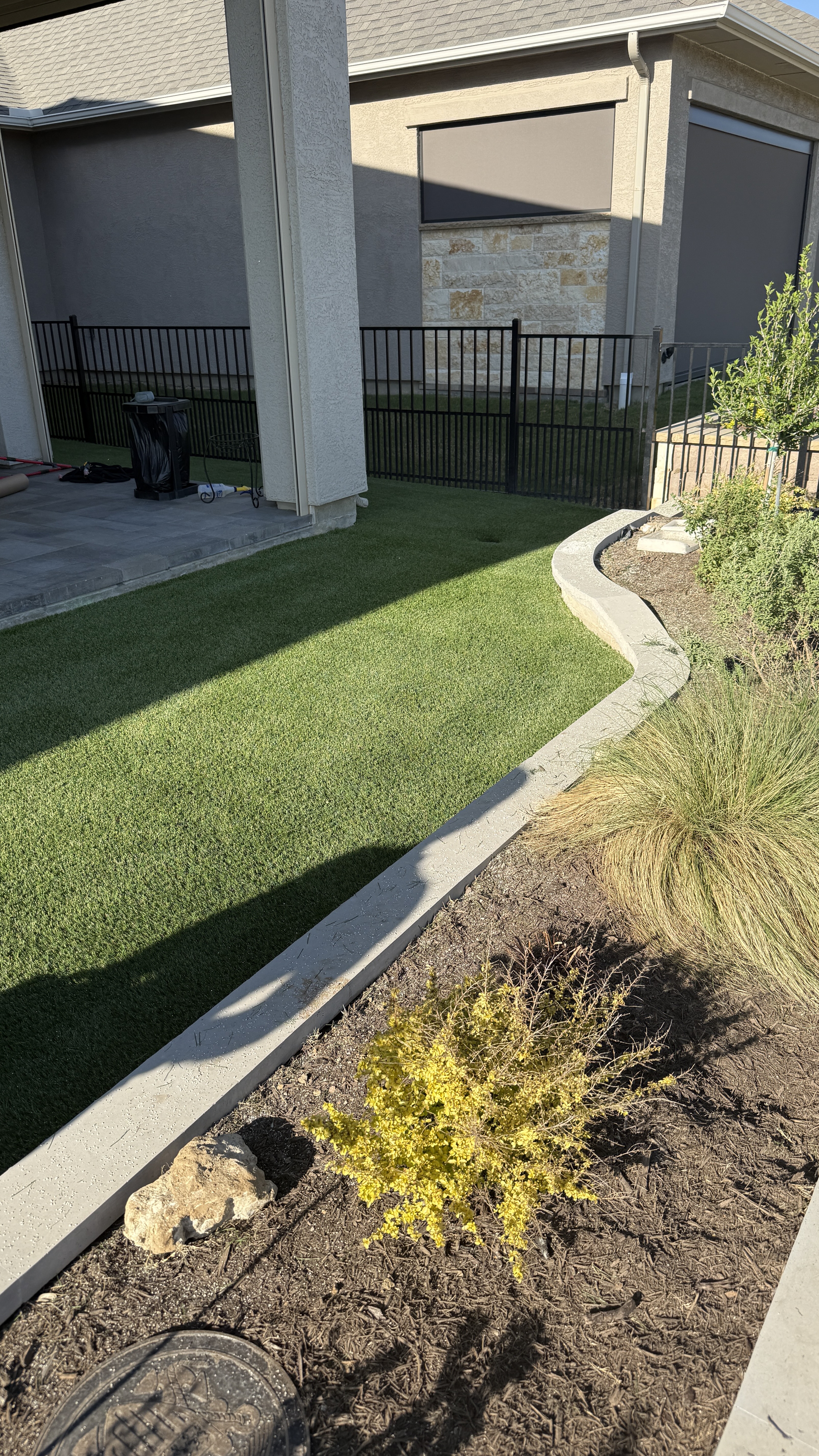 Backyard artificial turf installation with curved edging in DFW Texas