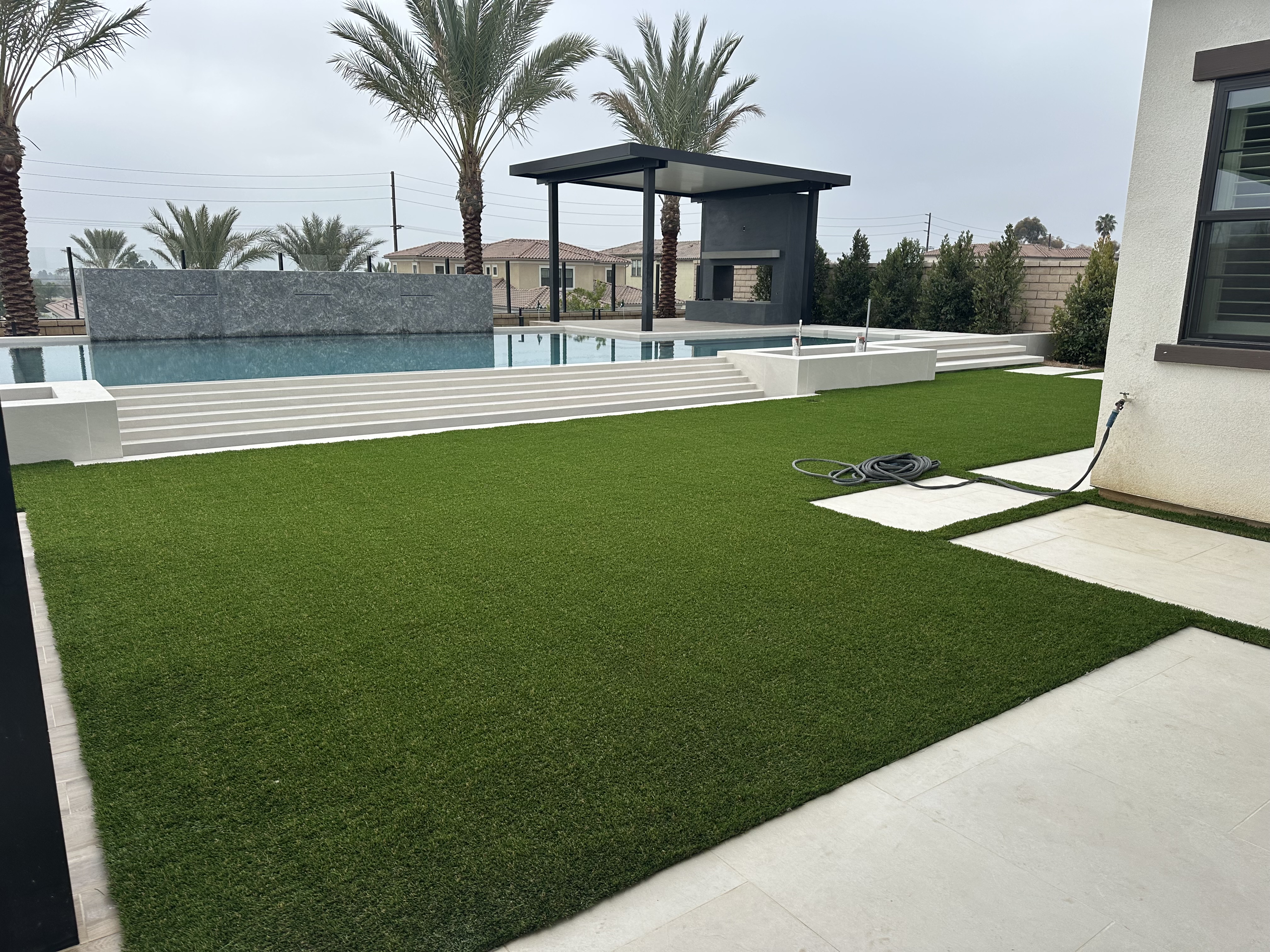 Luxury backyard artificial turf with pool and palm trees - Green Forever Turf Texas