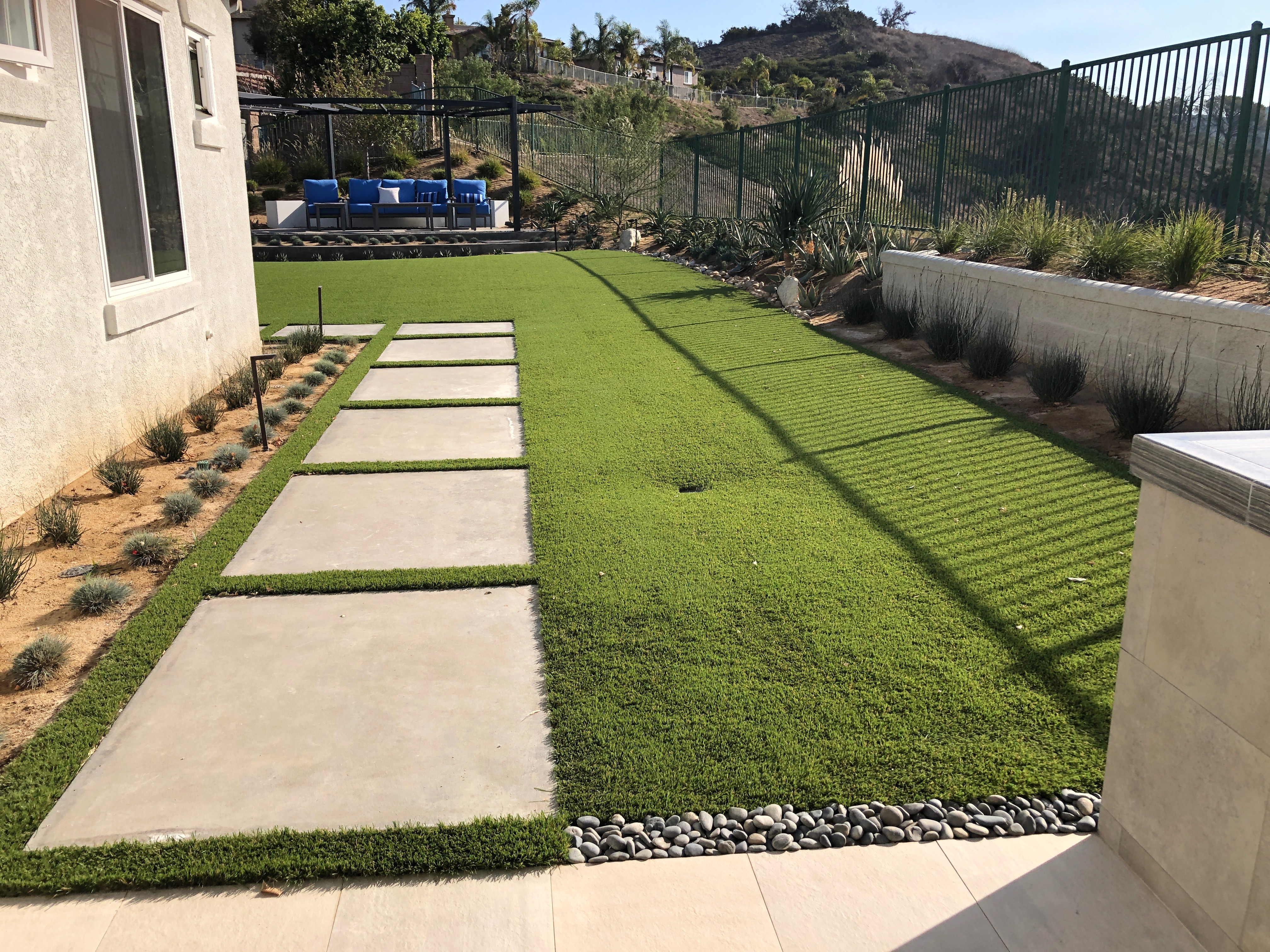 Side yard artificial turf between concrete pavers - Green Forever Turf Texas