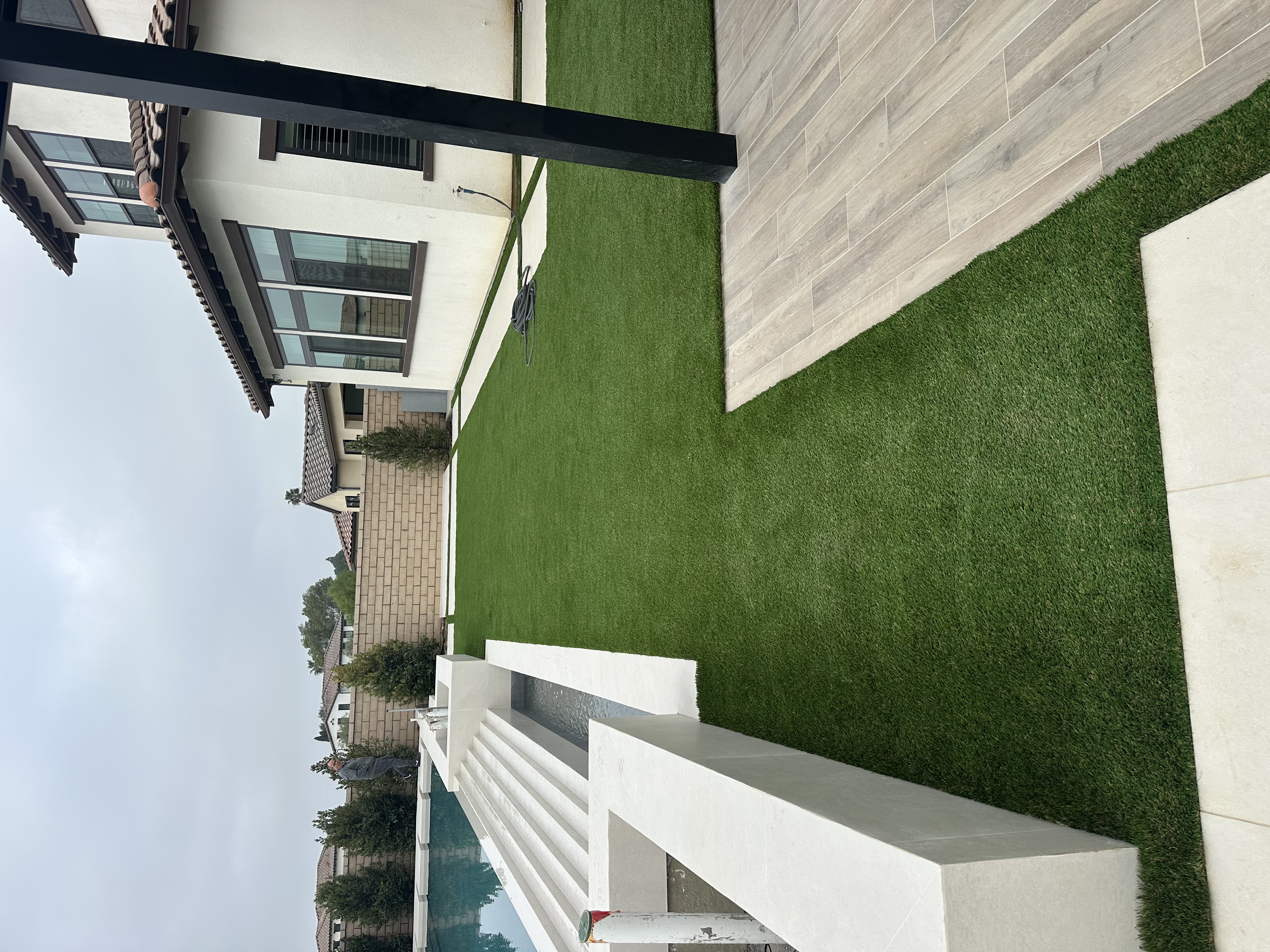 Side yard artificial turf with modern large-format pavers - Green Forever Turf Texas